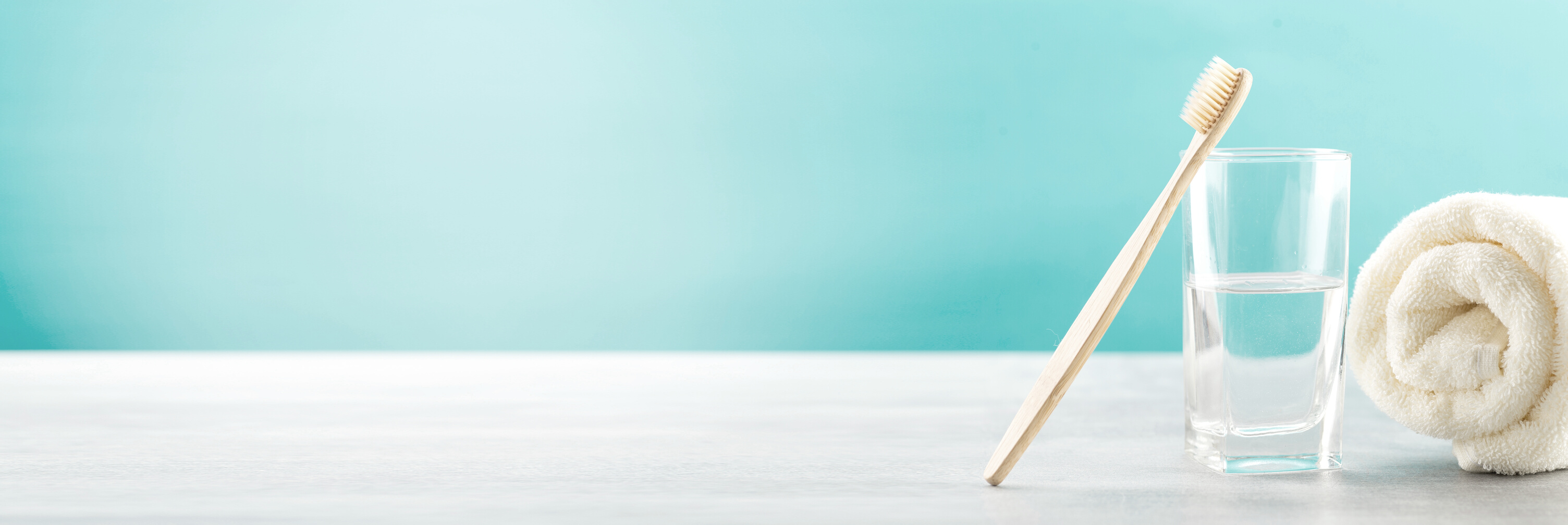 Bamboo Toothbrush in a Glass on Blue Background